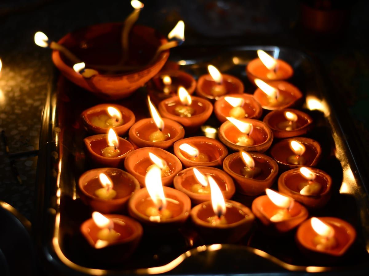 A tray of lit clay diyas