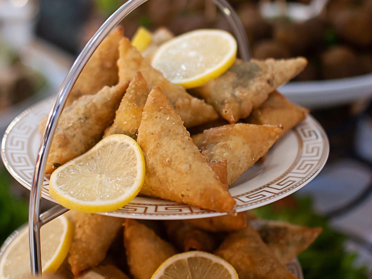 Samosas with lemon slices on a two-tier stand